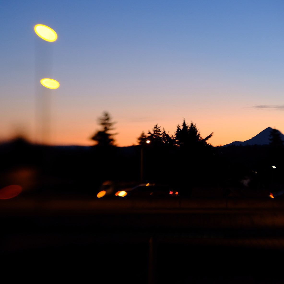A dark and distorted sunrise picture of Mt. Hood in silhouette.