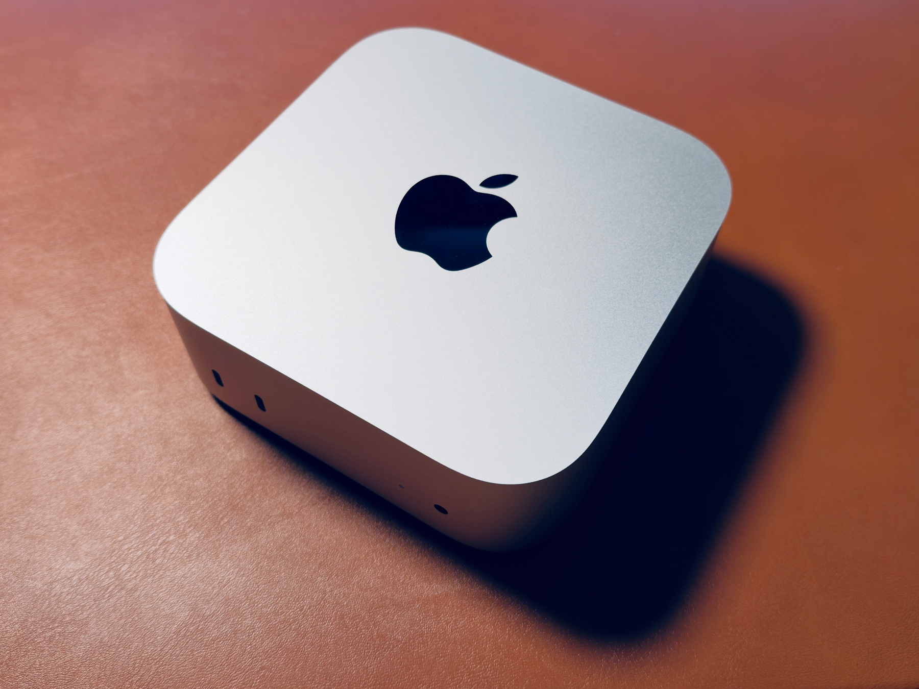 a Mac mini M4 Pro on a brown desk mat