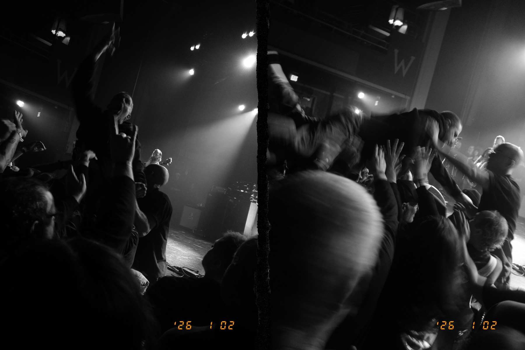 A person is crowd surfing over an excited audience at a lively concert.